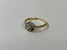 A gold cluster ring marked 18k, with five diamonds, one other stone and one stone missing, size N,