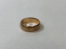 A foliage engraved gold wedding band, marked 9k, size N, weighs 2.71 grammes