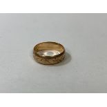 A foliage engraved gold wedding band, marked 9k, size N, weighs 2.71 grammes