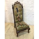 A Victorian rosewood nursing chair with C scroll surmount flanked by turned finial's on