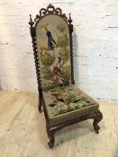 A Victorian rosewood nursing chair with C scroll surmount flanked by turned finial's on