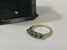 A sapphire and diamond gold ring, marked 9k, with five sapphires, separated by pairs of diamonds,