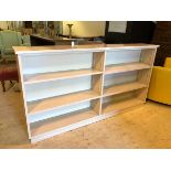 An open double bookcase the central divider flanked by single adjustable shelves over single fixed