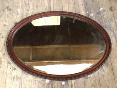 An oval wall mirror the bevelled glass within frame with moulded edge, (56cm x 81cm)