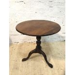 A George III mahogany tilt top table, the circular top on turned tripod support with having