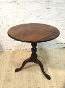 A George III mahogany tilt top table, the circular top on turned tripod support with having