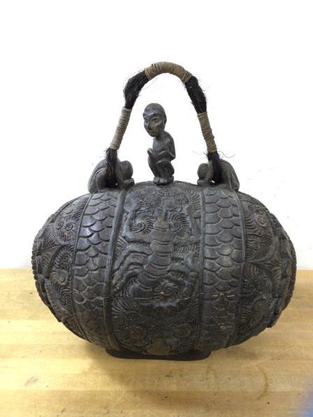 An African water carrier of ovoid form, having carved exterior with foliate design and scorpion to