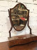 An Edwardian dressing table mirror the shield back glass on serpentine base with three frieze