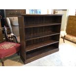 A 1920's 30's oak and pine open bookcase with three adjustable shelves on plinth base (106cm x 112cm