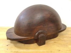 A wooden sculpture in the form of helmet inscribed to one side, LX8, separate down middle, (25cm x