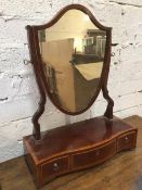 An Edwardian dressing table mirror with shield shaped glass over one long drawer and two short