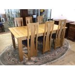 A contemporary oak extending dining table with magic leaf on straight supports, six matching