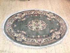 A Chinese oval rug with foliate design, (180cm x 284cm)