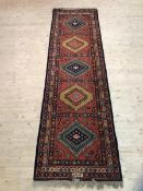 An Indian Mirzapur Kiamuri rug with five hooked diamonds within multiple flowerhead borders,