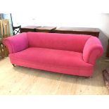 A Chesterfield sofa in pink upholstery on turned front supports terminating in castors, (71cm x