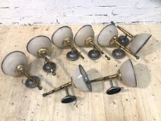 A group of eight wall lights with tapering supports with frosted glass shades having metal rims, (