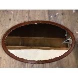 An oval wall mirror with moulded and beaded edge, (65cm x 106cm)