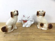 A pair of Staffordshire spaniels, (26cm h) and a novelty teapot in the form of a cat (3)