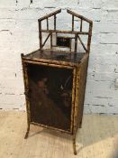 A cane and lacquered panel side cabinet the architectural super structure with lacquered and gilt