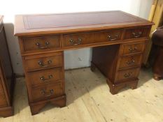 A modern yew wood pedestal desk the tooled leather top over frieze with three drawers, one
