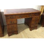 A modern yew wood pedestal desk the tooled leather top over frieze with three drawers, one