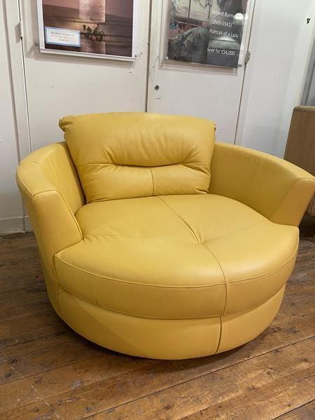 An oversized contemporary circular swivel lounge chair upholstered in yellow leather (84cm 130cm x