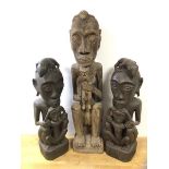 Three African fertility figures, depicting mothers holding children, with lizards on heads (