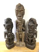 Three African fertility figures, depicting mothers holding children, with lizards on heads (