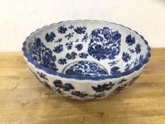 A large blue and white punch bowl with chinoiserie decorated, scalloped edge, crown over ironstone