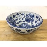 A large blue and white punch bowl with chinoiserie decorated, scalloped edge, crown over ironstone