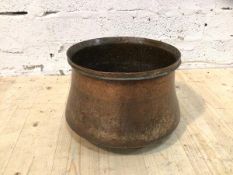 An early 20thc beaten copper bin with rounded base, lacking top, (23cm x 33cm)