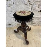 A Victorian mahogany rise and fall music stool, circular top with floral grospoint seat above