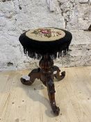 A Victorian mahogany rise and fall music stool, circular top with floral grospoint seat above