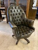 A modern leather desk chair with buttoned back, arms and seat, scrolled arms, studded to front, on