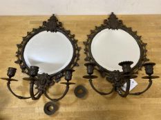 A pair of patinated metal girandole mirrors, each circular bevelled plate within frames