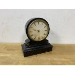 An Edwardian mantel clock, the ebonised wooden frame with circular dial and roman numerals, movement