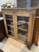 A 1930's / 40's oak bookcase the rectangular top with ledgeback over carved frieze with animal