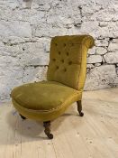 A Victorian slipper chair with scrolled button back, on turned front supports, terminating in