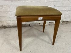 A mid century teak stool with upholstered seat on tapering supports,