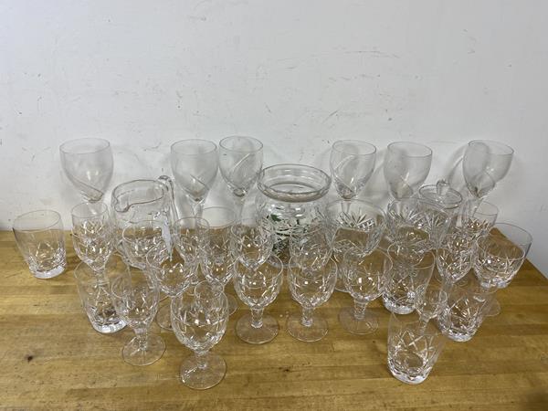 A collection of glassware including wine and liquor glasses, tumblers, a water jug and a biscuit