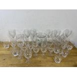 A collection of glassware including wine and liquor glasses, tumblers, a water jug and a biscuit