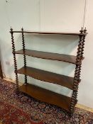 A Victorian mahogany Whatnot with four serpentine shelves supported by barley twists on turned feet,