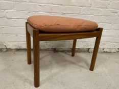 A mid century teak stool the loose seat cushion above seat with convex long ends, on circular