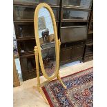 A cheval mirror with oval glass on trestle support, measures 149cm high x 58cm