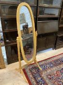 A cheval mirror with oval glass on trestle support, measures 149cm high x 58cm