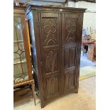 A 1920's Gothic revival wardrobe, the moulded top over two panel doors decorated with tray foils,