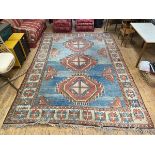 A caucasian rug with three diamond medallions and stylised flowerheads to corners and sides of the