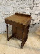 A 19thc mahogany Davenport the hinged superstructure with pen tray and recesses over slant hinged