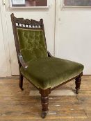 An Edwardian easy chair with carved crest rail with floral decoration