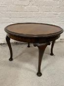 A Georgian inspired mahogany circular coffee table with dished top, moulded edge on four cabriole